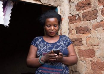 woman on phone Jane Zamukunda (28) accesses Barefoot Law's free legal advice through her mobile phone at her brother's house in Kawempe, Kampala on 19th May 2017.